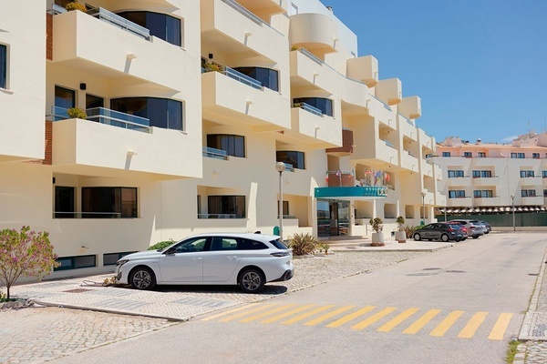 a white car is parked in front of a hotel