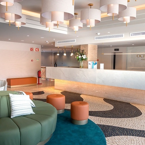 el vestíbulo del hotel oceanus con un sofá y taburetes