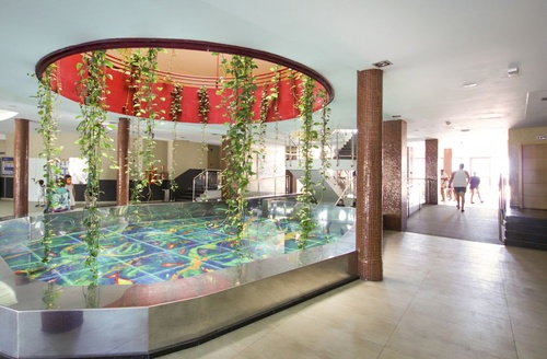 Hall de entrada Ohtels Mazagón com tanque decorativo e escadas.