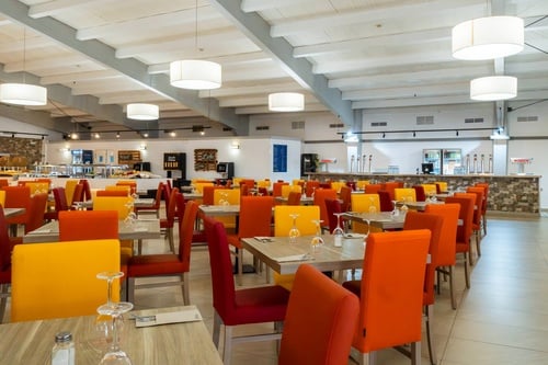 une salle à manger remplie de tables et de chaises colorées
