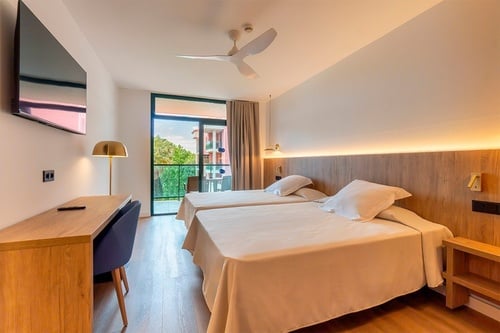 una habitación de hotel con dos camas y un ventilador de techo