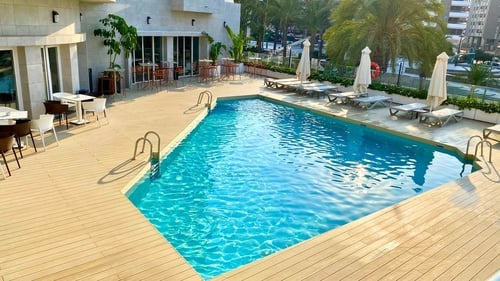 a swimming pool with a table and chairs in front of it