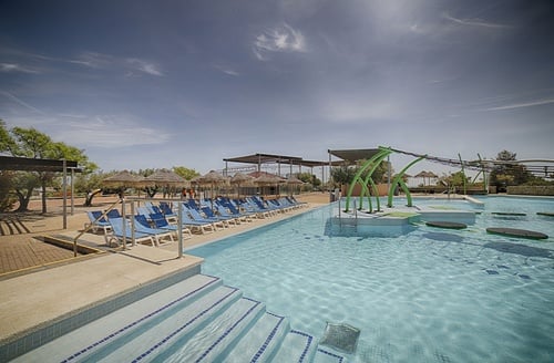 Hotel Perelló: piscina con tumbonas y juegos acuáticos en Ohtels Les Oliveres.