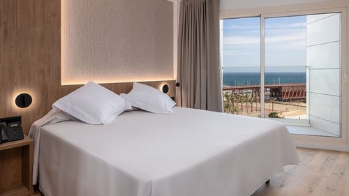 una habitación con una cama y una ventana con vista al océano
