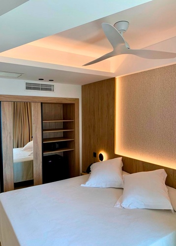 una habitación con una cama y un ventilador de techo