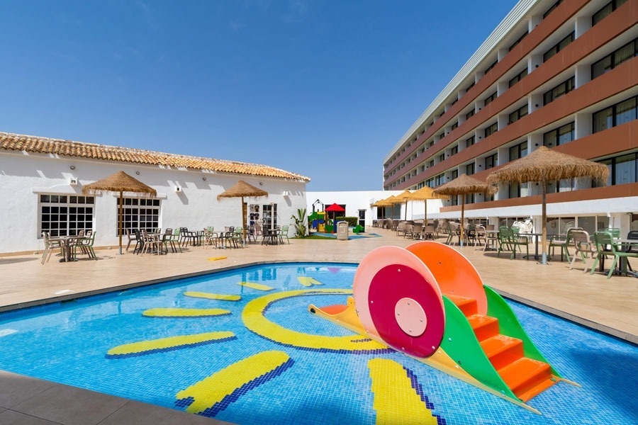 une petite piscine avec un toboggan en forme de soleil