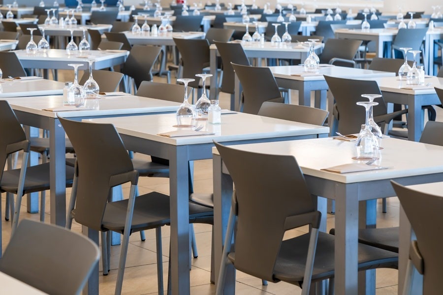 tables and chairs in a restaurant with wine glasses on them