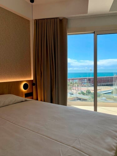 una habitación con una cama y una ventana con vista al océano