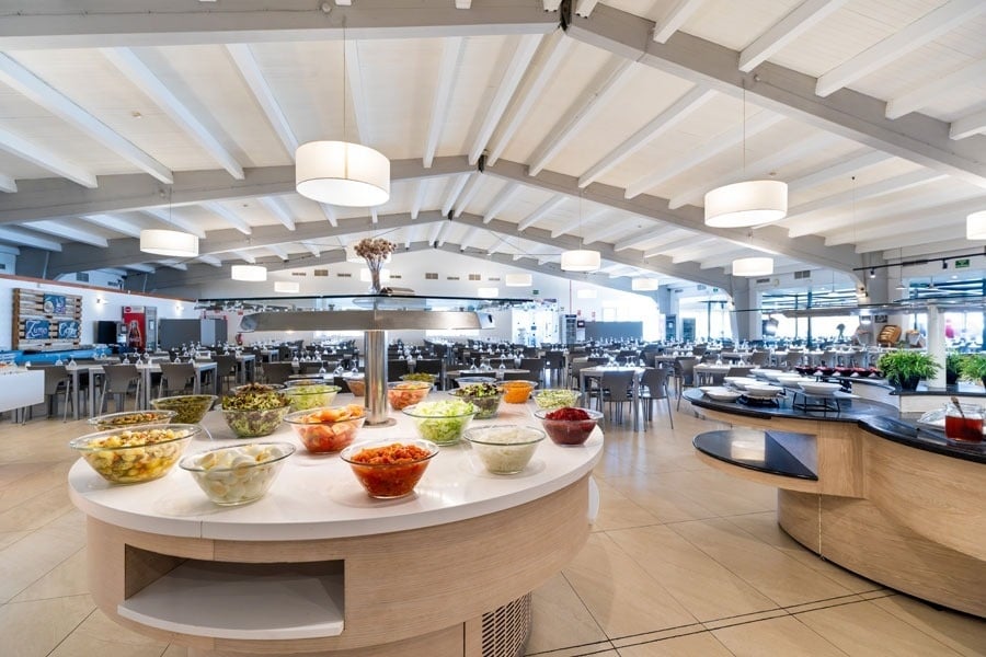 uma grande sala de jantar com uma mesa cheia de tigelas de comida