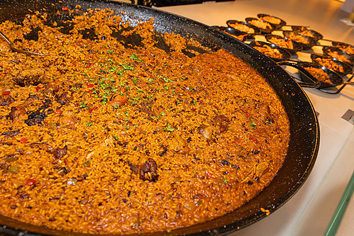 Paella gigante com frutos do mar Hotel tudo incluído em La Pineda | Ohtels La Hacienda em uma frigideira grande, servida em pequenas porções.
