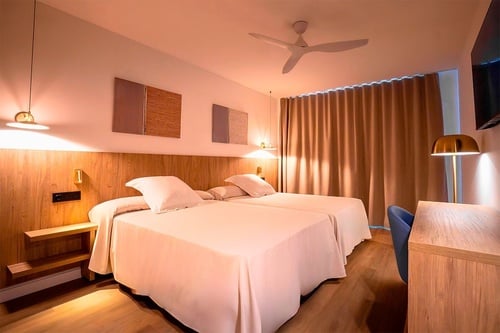 una habitación de hotel con dos camas y un ventilador de techo