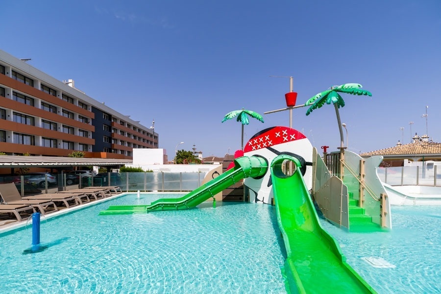 uma piscina com um escorregador verde e um barco pirata