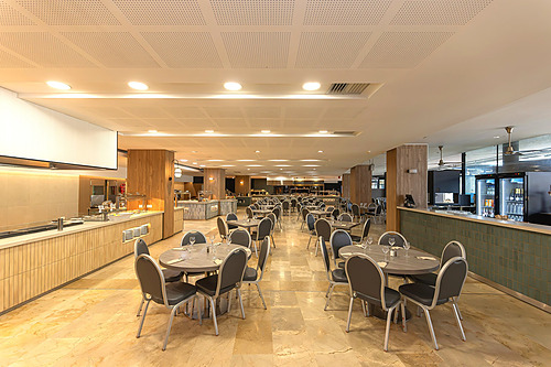Comedor buffet del Hotel Ohtels Les Oliveres con mesas redondas y barra de autoservicio.
