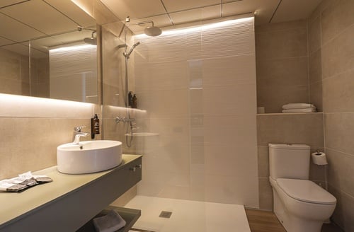 Hotel en Matalascañas: Baño moderno con ducha y lavabo elegante.