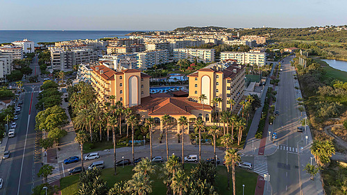 Vista aérea do Hotel tudo incluído em La Pineda | Ohtels La Hacienda à beira-mar com piscinas e palmeiras.