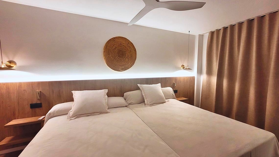 une chambre avec un lit et un ventilateur au plafond