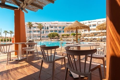 una mesa y sillas en una terraza con vistas a una piscina