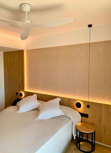 una habitación con una cama y un ventilador de techo