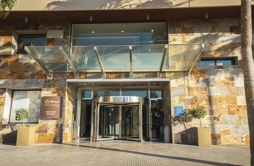 Hotel entrance with revolving doors and welcome sign at Hotel Campo de Gibraltar in La Línea de la Concepción.