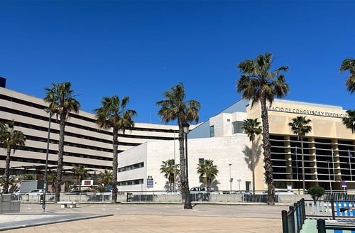 Hotel in La Linea de la Concepcion: Modern hotel with palm trees and exhibition center.