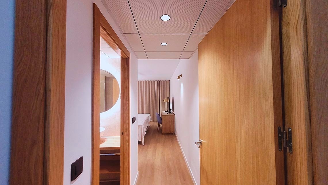 un couloir d' une chambre d' hôtel avec une porte en bois ouverte