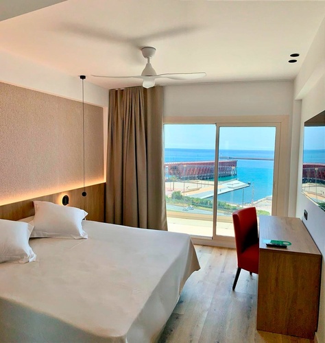una habitación con una cama y una ventana con vista al océano