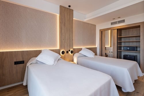 una habitación de hotel con dos camas y un armario