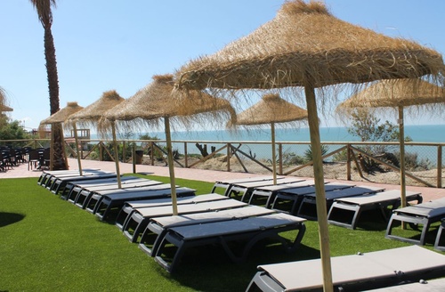 Hotel tudo incluído em Mazagón, Huelva: espreguiçadeiras e guarda-sóis junto ao mar no Ohtels Mazagón.
