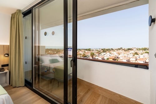 a hotel room with a sliding glass door leading to a balcony