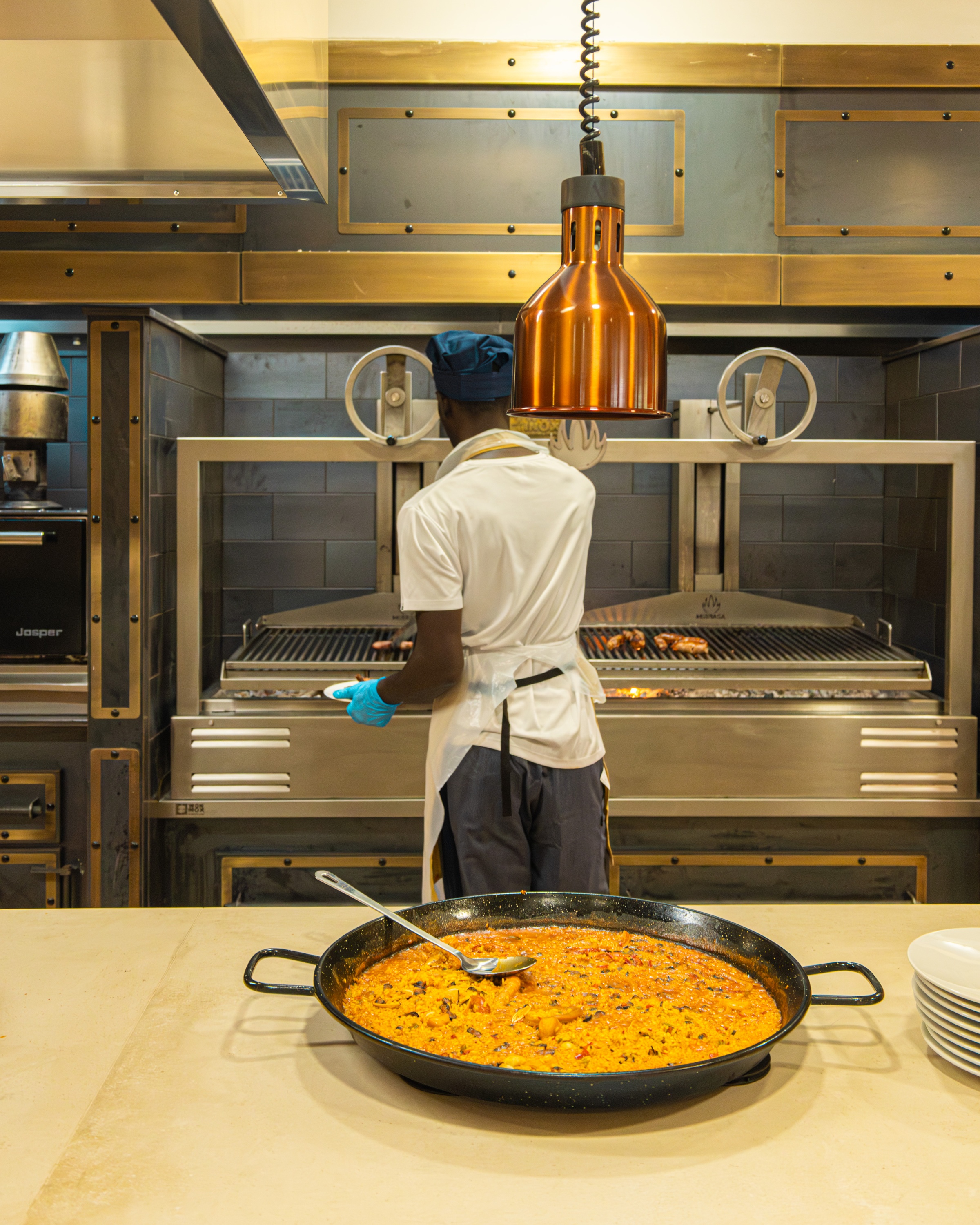 Chef en Ohtels: Corporativa sirviendo paella en parrilla.