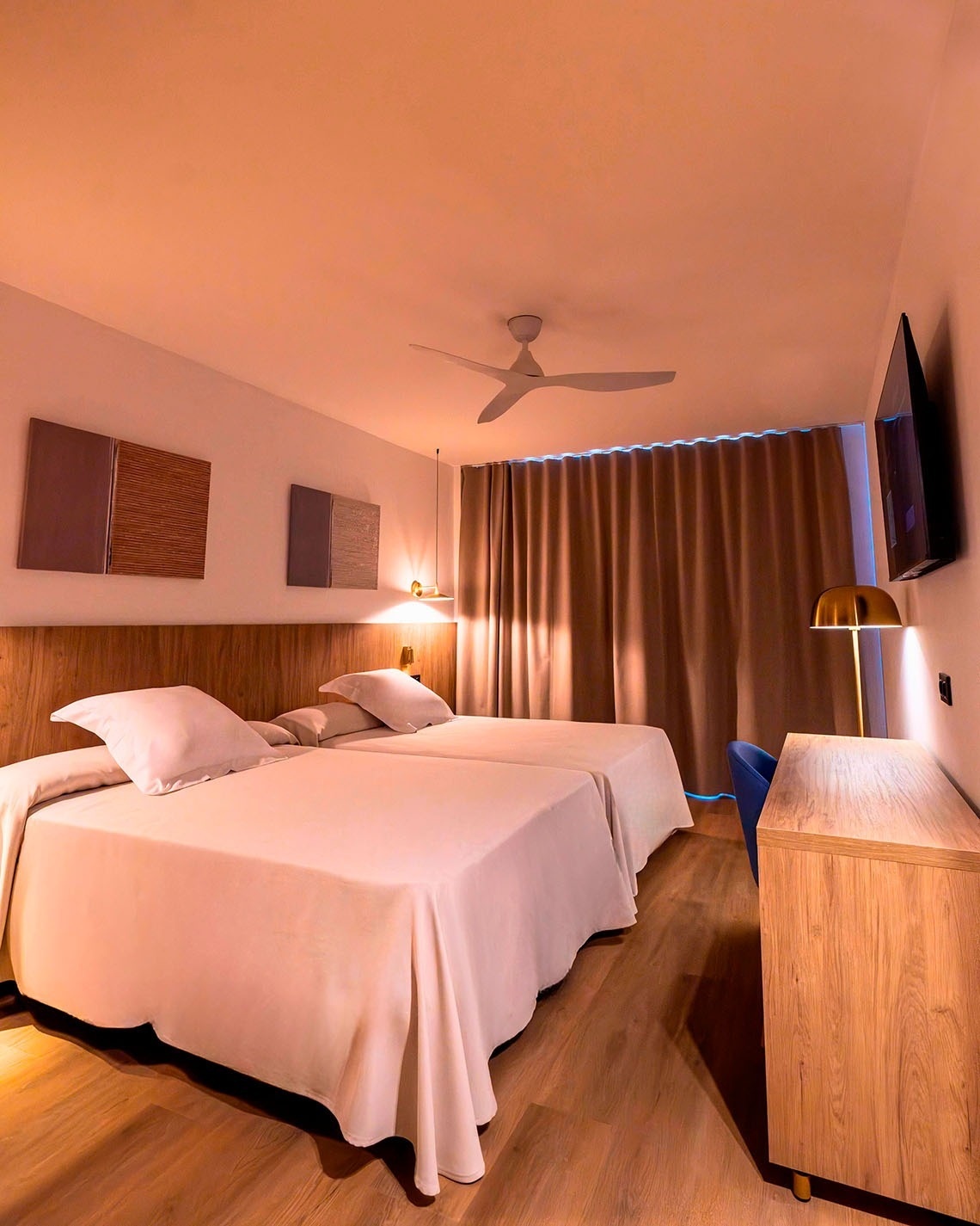 una habitación de hotel con dos camas y un ventilador de techo