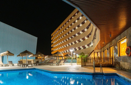 Piscina nocturna y edificio del Hotel Ohtels Campo de Gibraltar en La Línea.