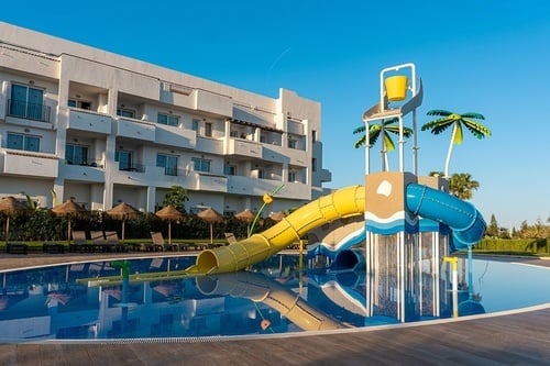 una piscina con un tobogán y un edificio en el fondo