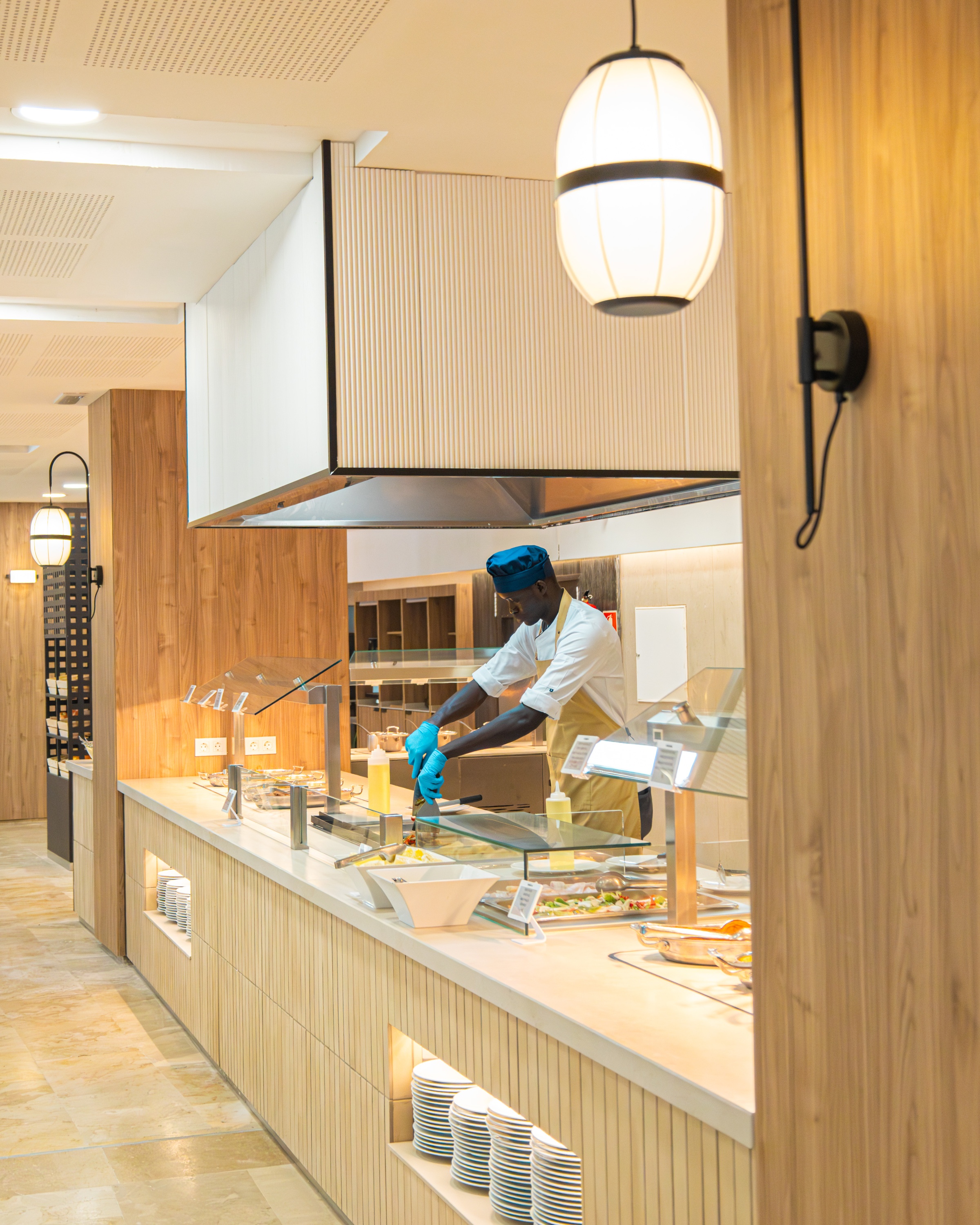 Chef preparando comida en el buffet Ohtels Corporativa, ideal para eventos y banquetes.