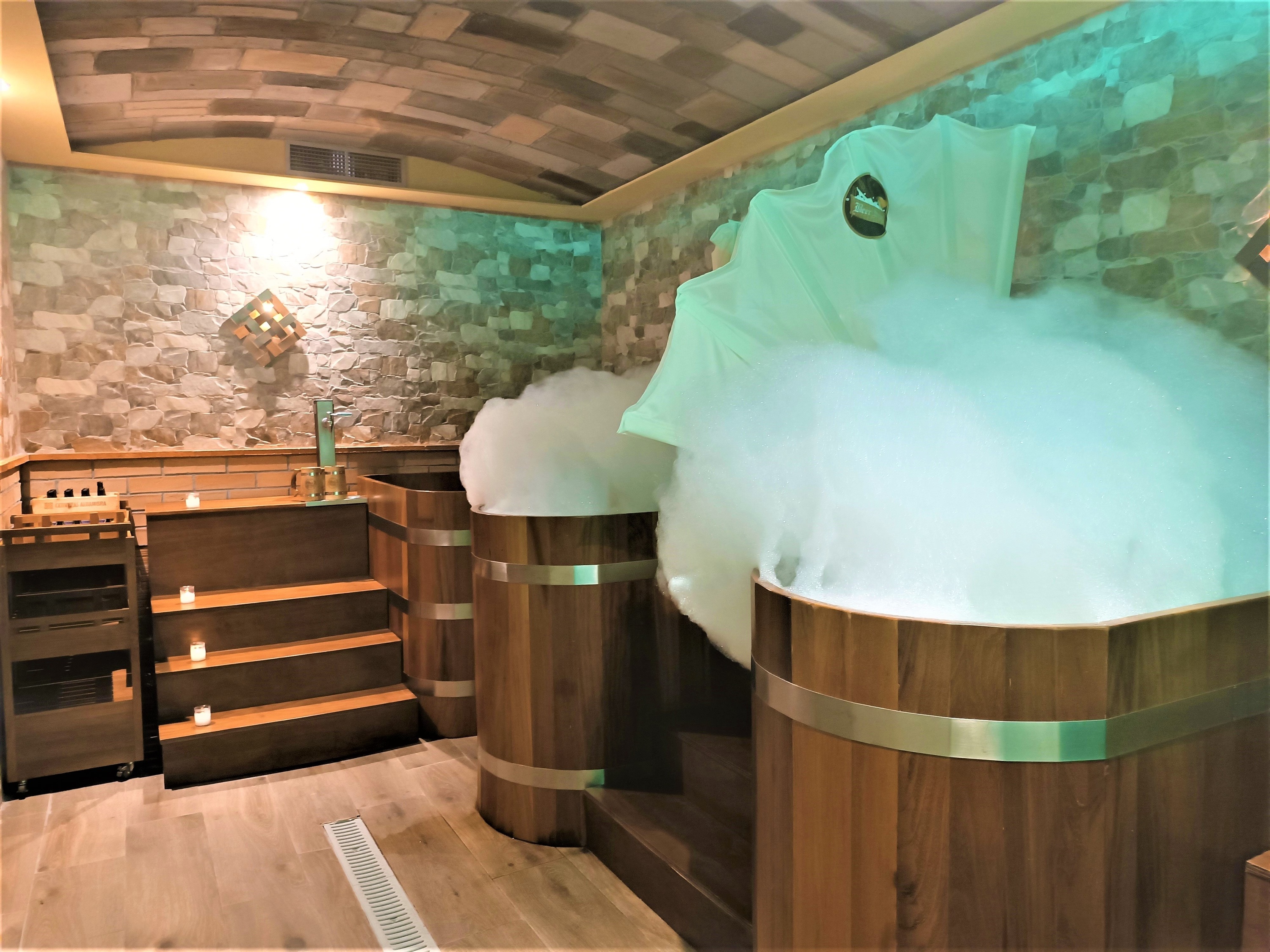 dos barriles de madera llenos de espuma en un spa