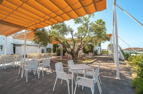 Comedor exterior bajo toldo naranja en Hotel en Matalascañas | Ohtels Carabela Beach & Golf.