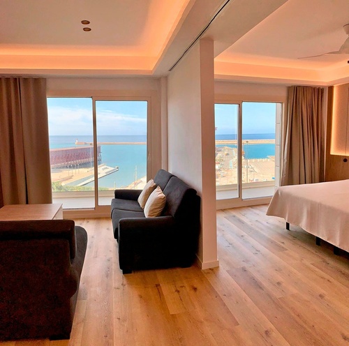 una habitación con un sofá y una cama con vista al océano