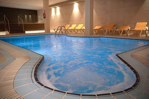 a swimming pool with a jacuzzi in the middle of it