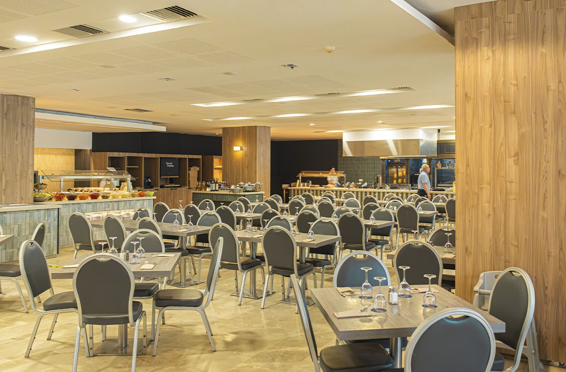 Ohtels: amplio salón comedor con mesas puestas y buffet para eventos corporativos.