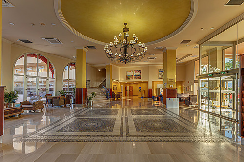Lobby do hotel: recepção, escada, móveis de vime e lustres. Hotel tudo incluído em La Pineda | Ohtels La Hacienda