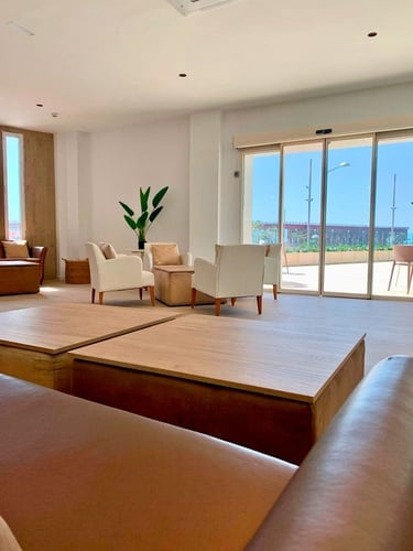 una sala de estar con sofás y sillas y mesas de madera