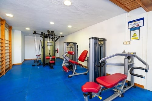 un gimnasio con una señal de advertencia en la pared