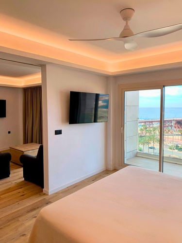 una habitación con una cama y un televisor en la pared