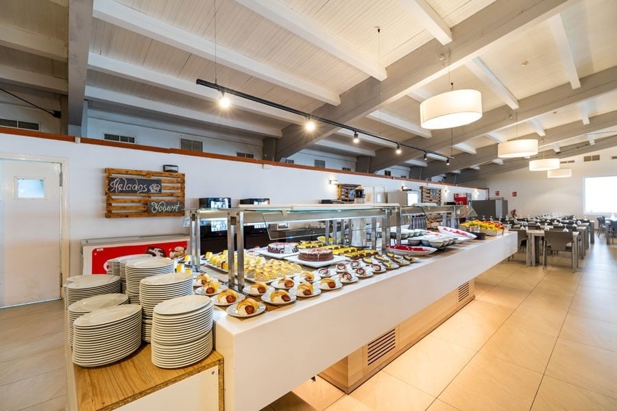 une salle à manger remplie de plats et de desserts avec un panneau sur le mur qui dit " helados "