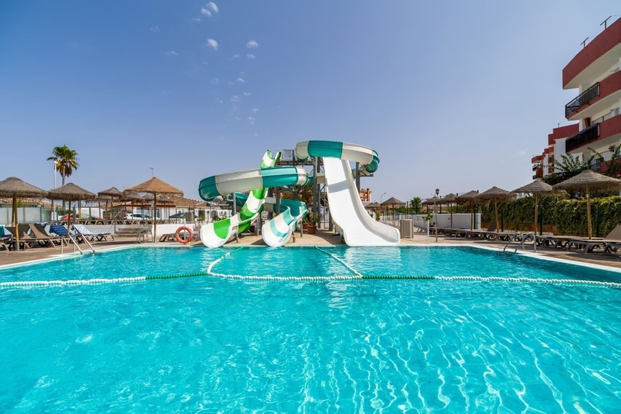 a large swimming pool with a water slide in the middle