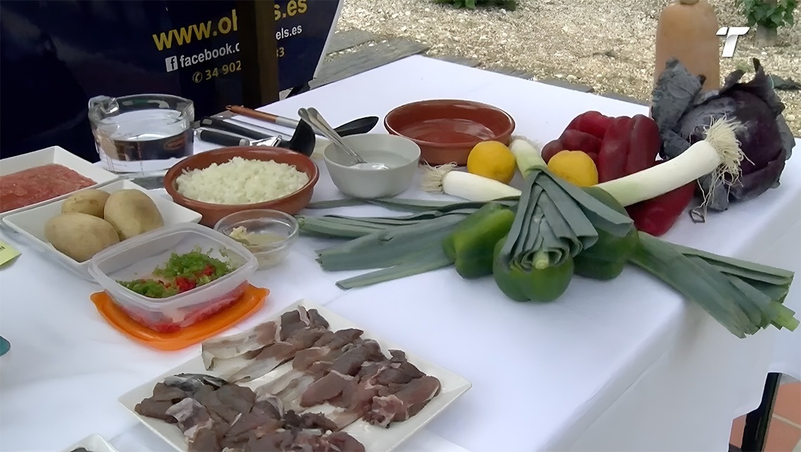 une table avec des légumes et de la viande à côté d' un panneau facebook