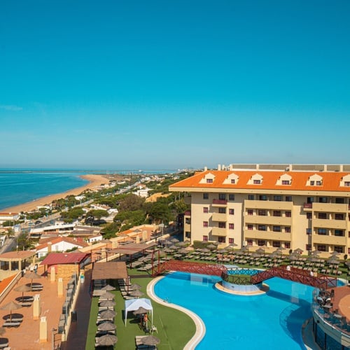 una vista aérea de un hotel con una piscina al fondo