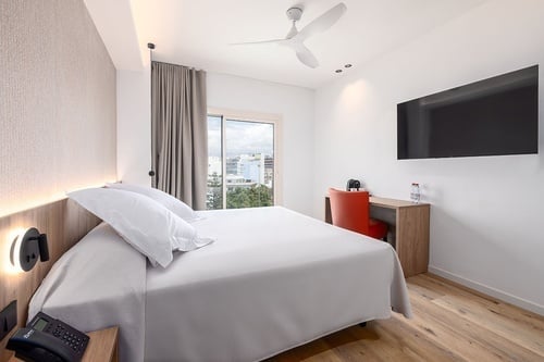 una habitación de hotel con una cama y una televisión