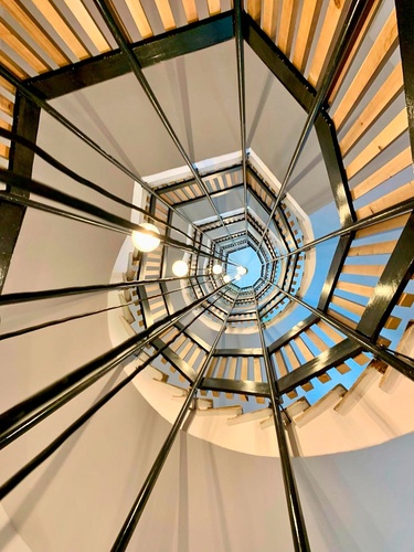 una escalera en espiral con barandas de madera y metal