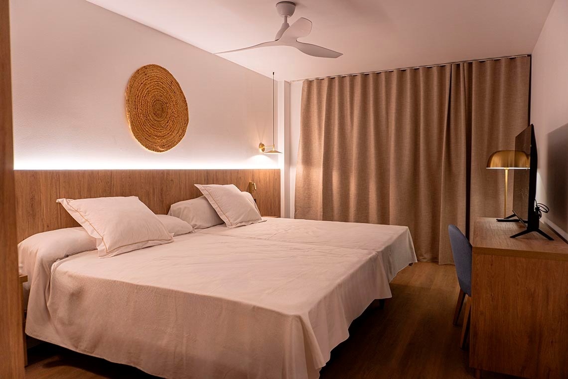une chambre avec deux lits et un ventilateur de plafond
